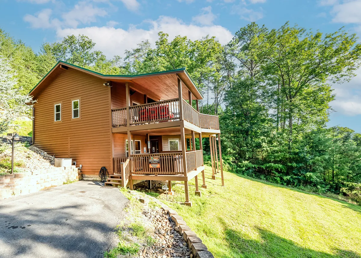 An inviting wooden deck surrounded by greenery, with ample space for seating and group activities. The scene suggests relaxation, socializing, and enjoying nature from the comfort of the property.