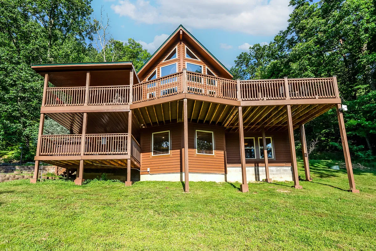 A welcoming view of the lodge’s spacious wooden deck, with large windows and a triangular roof visible. Ideal for outdoor gatherings, barbecues, or simply relaxing while enjoying the sunset over the Smoky Mountains.